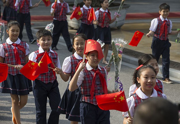 Các thiếu nhi vẫy cờ chào mừng tại lễ đón tiếp - Ảnh: Việt Dũng