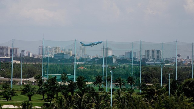 Qua lớp rào lưới chắn bóng, có thể nhìn thấy máy bay đang cất cánh.