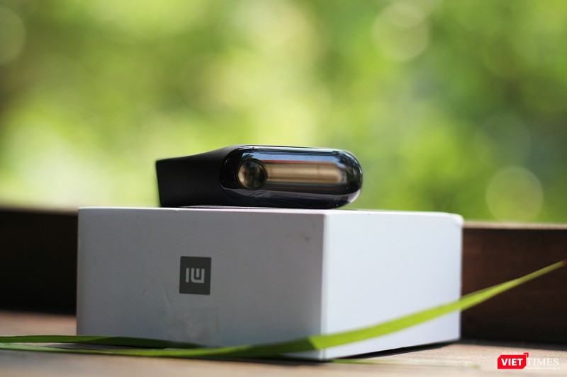 Còn đây là chiếc Mi Band 3. Chúng ta có thể thấy nó có mặt kính với nút cảm ứng khá to, hơi lồi so với Mi Band 2. Vỏ nhựa hình viên thuốc, có thể dễ dàng lắp vào dây đeo cao su