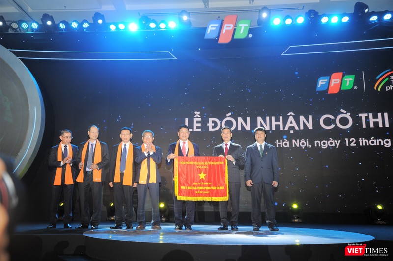 quyền Bộ trưởng Bộ Thông tin Truyền thông Nguyễn Mạnh Hùng thay mặt Chính phủ trao cờ thi đua cho đại diện FPT