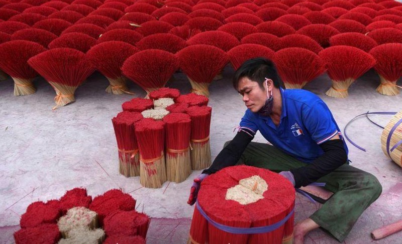 Một công nhân gói nhang khô trong sân ở làng Quảng Phú Cầu (ảnh: Reuters) Một công nhân gói nhang khô trong sân ở làng Quảng Phú Cầu (ảnh: Reuters)