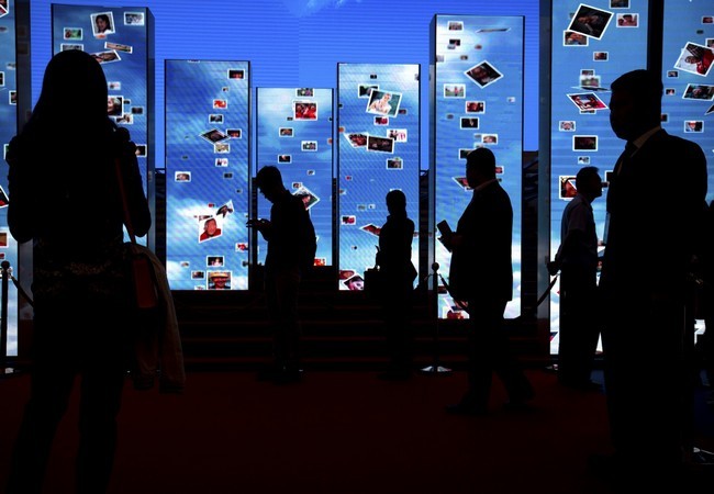 Khách tham quan bước qua các màn hình video tại một triển lãm trưng bày các thành tựu của Trung Quốc đạt được sau 5 năm dưới sự lãnh đạo của chủ tịch Trung Quốc Tập Cận Bình tại Trung tâm Triển lãm Bắc Kinh, Trung Quốc ngày 28.09.2017 (ảnh AP)