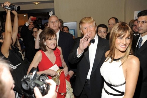 Tỷ phú Donald Trump (giữa) và vợ mình (áo trắng) trong vòng vây phóng viên. Ảnh:AP