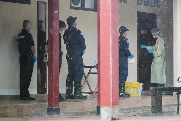 Các nhân viên của Lực lượng Phòng vệ dân sự Singapore chuẩn bị vào phòng của một người nghi nhiễm Covid-19 tại một cơ sở cách ly để lấy mẫu bệnh phẩm. Ảnh: TNP