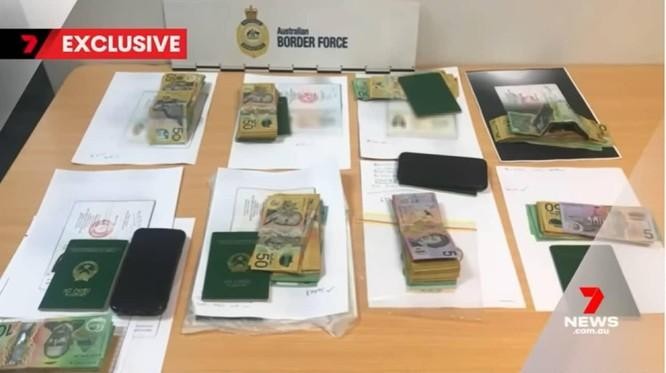 Hình ảnh từ bản tin của 7News thể hiện rõ các cuốn hộ chiếu mang quốc huy Việt Nam trong tang vật vụ việc. (Ảnh cắt từ clip)