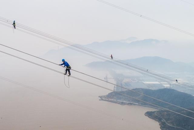 Công nhân đang làm việc trên hệ thống đường dây điện cao thế tại Trung Quốc. Ảnh: Getty.