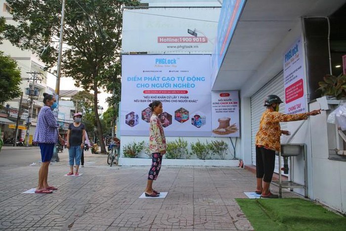 Xếp hàng chờ phát gạo miễn phí, mỗi người cách nhau 2m (Ảnh: Hoàng Triều)