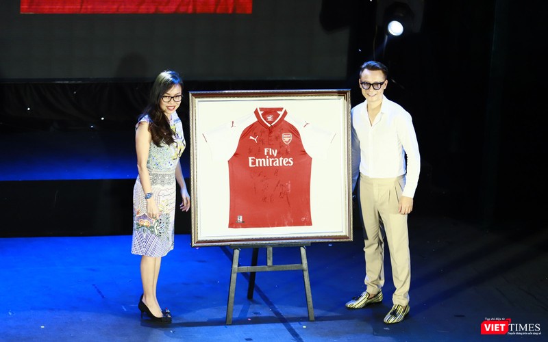 Người tặng áo (bên trái ảnh) và ca sĩ Hoàng Bách lên nhận thay vợ đã đấu giá thành công chiếc áo có chữ ký của các cầu thủ đội tuyển Arsenal - 1000$