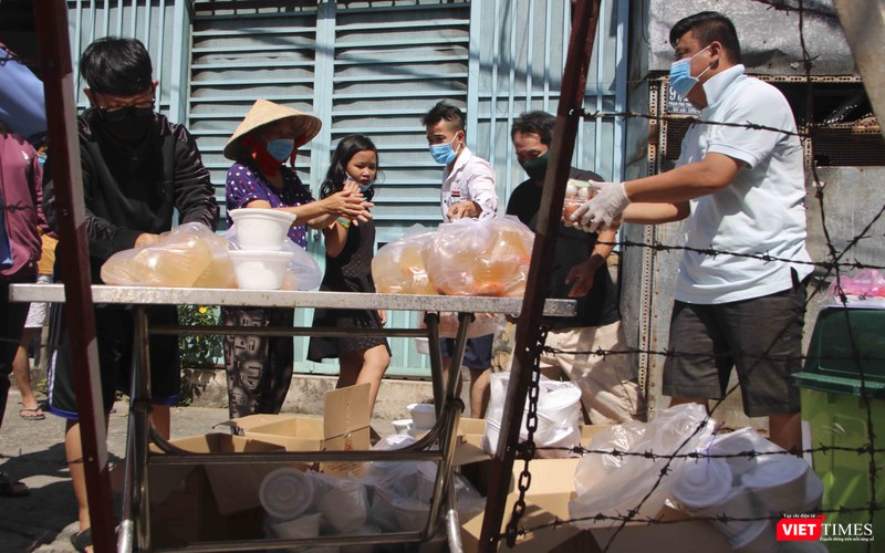 Người dân trong vùng cách ly Quận 6 nhận phần cơm tiếp tế (Ảnh: Hải Linh)