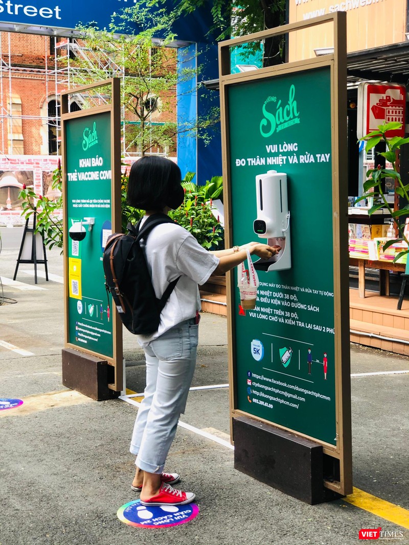 Độc giả đo thân nhiệt và rửa tay trước khi vào Đường sách