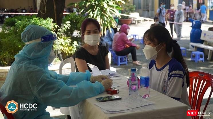 Phụ huynh ký giấy đồng ý tiêm vắc xin COVID-19 cho con. Ảnh: HCDC