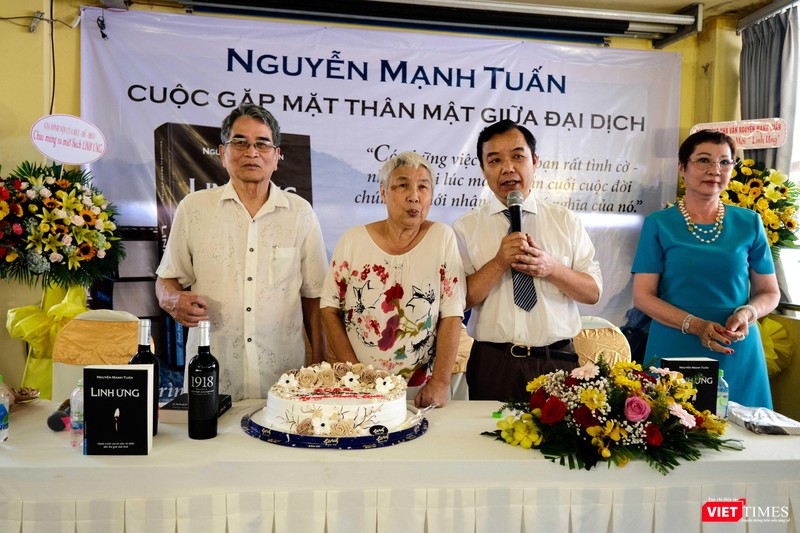 Nhà văn Nguyễn Mạnh Tuấn cùng vợ chuẩn bị cắt bánh chúc mừng vì cuốn sách "Linh ứng" được phát hành