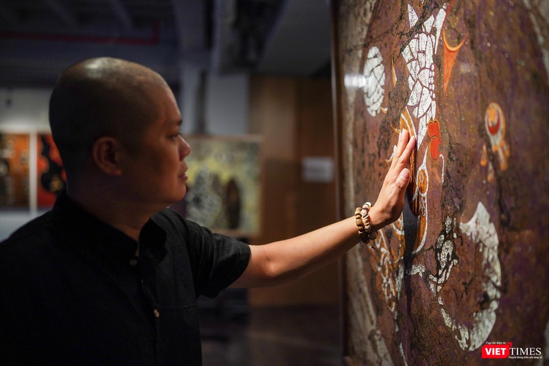 Họa sĩ Trần Ngọc Hưng bên những tác phẩm đang trưng bày tại Ngõ Art Gallery. Ảnh: Phạm Nguyễn 