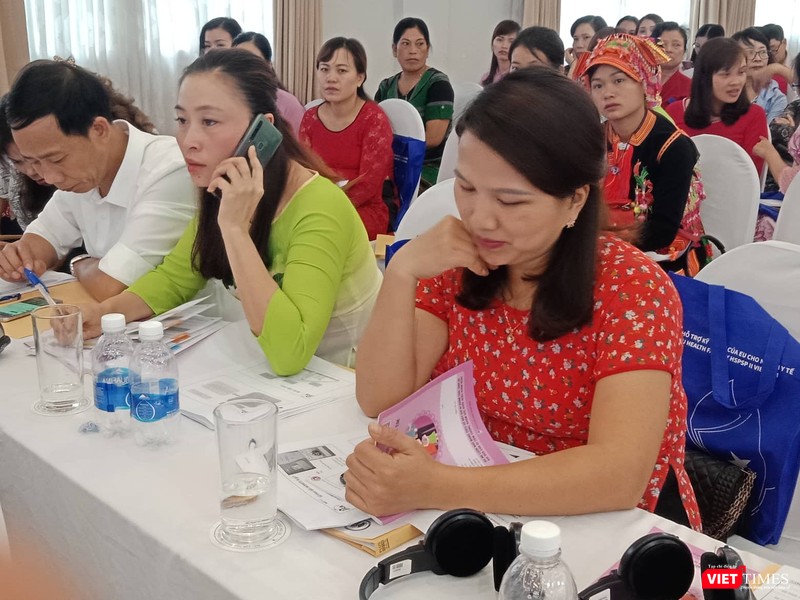 Các đại biểu tại Hội nghị xem sổ theo dõi sức khỏe bà mẹ và trẻ em