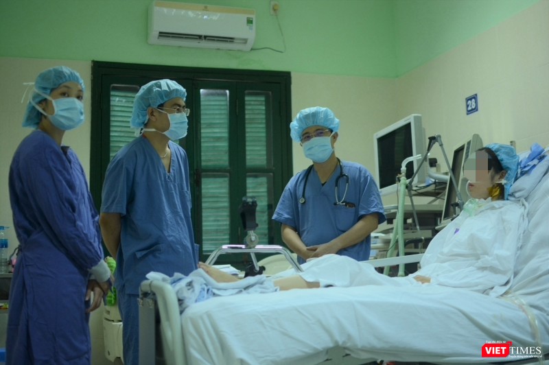 Bác sĩ giúp chị H. tập phục hồi chức năng tại giường (Ảnh: Quang Hùng)