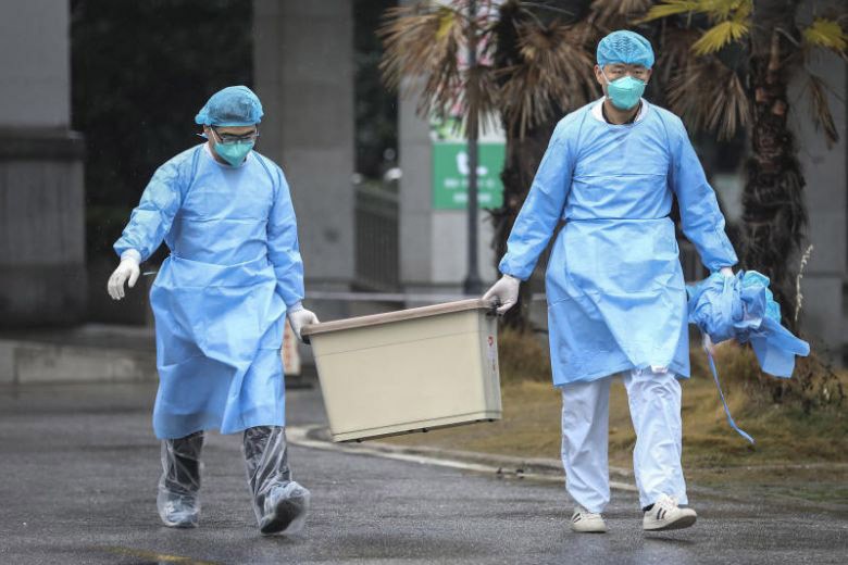 Nhân viên tại Trung tâm Y tế TP Vũ Hán (Trung Quốc) - nơi đang điều trị cho một số bệnh nhân mắc viêm phổi lạ - xử trí bệnh phẩm (Ảnh: The Straits Times)