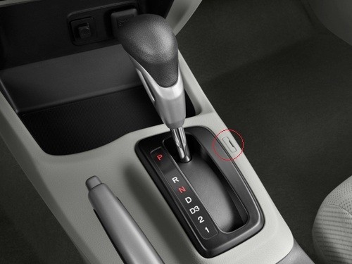 Nút Shift lock ở khu cần số  Nút Shift Lock trên khu cần số ô tô có chức năng mở khóa giúp tài xế sang số khi không nổ máy. Trên xe số tự động, cần số bị khóa nếu chưa nổ máy. Nếu gặp trường hợp xe hết ắc-quy, chết máy giữa đường, lúc này nút “Shift Lock” sẽ phát huy tác dụng. Trên một số xe làm nút này nhô cao, tài xế ấn giữ vào đó để di chuyển cần số. Nhưng trên xe khác nút này lại bị ẩn, chỉ có một nắp nhỏ như trên hình vẽ. Lúc đó cần sử dụng vật mỏng, cứng gỡ nắp đậy ra, sau đó gạt lẫy nhỏ phía trong để di chuyển cần số.