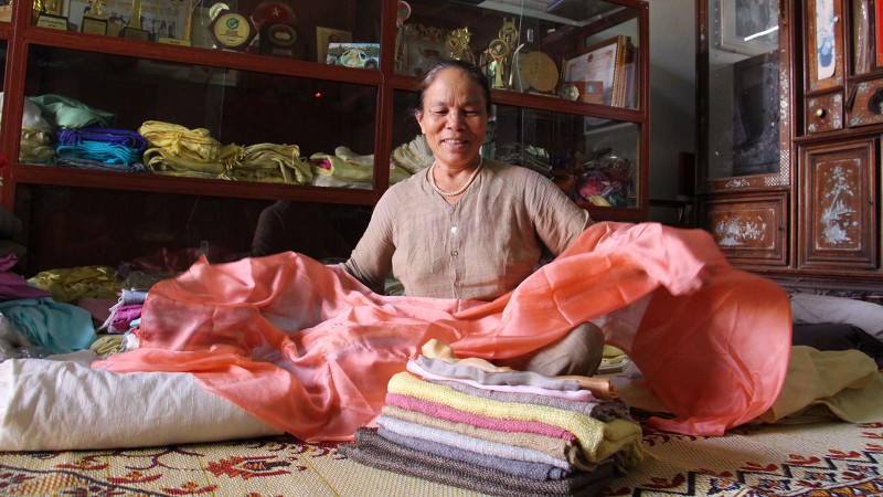 NNƯT Phan Thị Thuận và những thước lụa từ tơ tằm tại xưởng của bà. Với sự chăm chỉ, luôn mày mò sáng tạo bà đã nhận được rất nhiều bằng khen và giải thưởng trong nước về lĩnh vực tơ tằm. Ảnh: Thục Nhi NNƯT Phan Thị Thuận và những thước lụa từ tơ tằm tại xưởng của bà. Với sự chăm chỉ, luôn mày mò sáng tạo bà đã nhận được rất nhiều bằng khen và giải thưởng trong nước về lĩnh vực tơ tằm. Ảnh: Thục Nhi