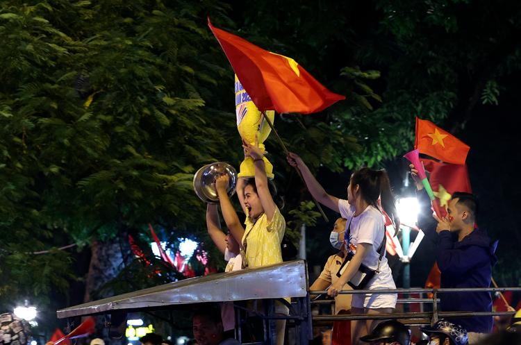 Nhiều người còn ngồi lên cả thùng xe 3 bánh để phất cờ, nhảy múa, hát ca, hô vang Việt Nam chiến thắng.