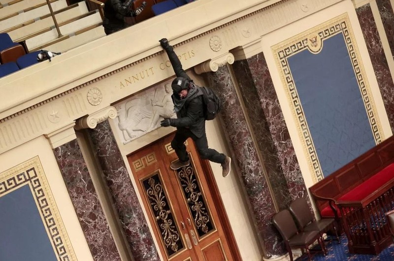 Một người biểu tình cheo leo trên ban công của Thượng viện (Ảnh: AFP)