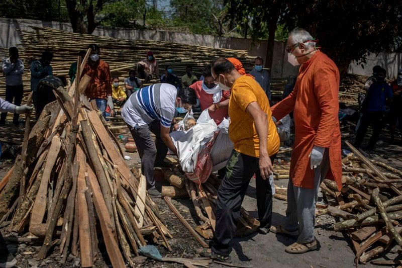 Nhóm người đưa thi thể người thân chết do COVID-19 lên dàn hỏa táng ở New Delhi, ngày 24/4 (Ảnh: AP)