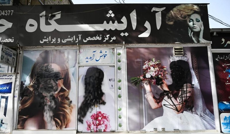 Nhiều tấm poster quảng cáo bên ngoài một tiệm làm đẹp bị xóa bỏ thô bạo (Ảnh: AFP)