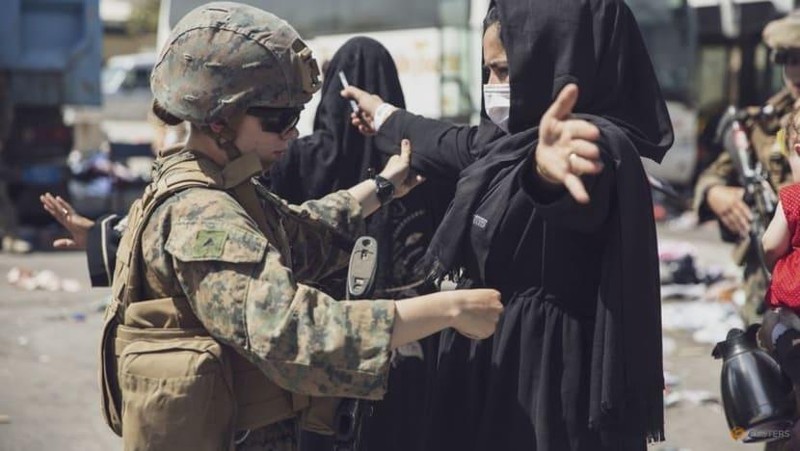 Một người phụ nữ được kiểm tra an ninh tại Trung tâm Kiểm soát Sơ tán (EEC) tại sân bay Kabul (Ảnh: Reuters)