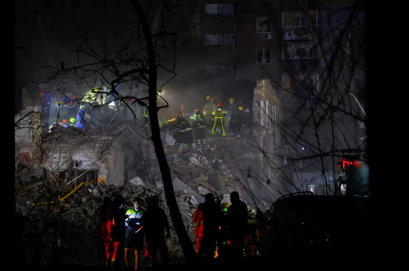 Lực lượng cứu hộ làm việc tại hiện trường một tòa nhà chung cư bị trúng tên lửa đạn đạo của Nga tại Kiev, Ukraine ngày 24/4. Ảnh: Reuters.