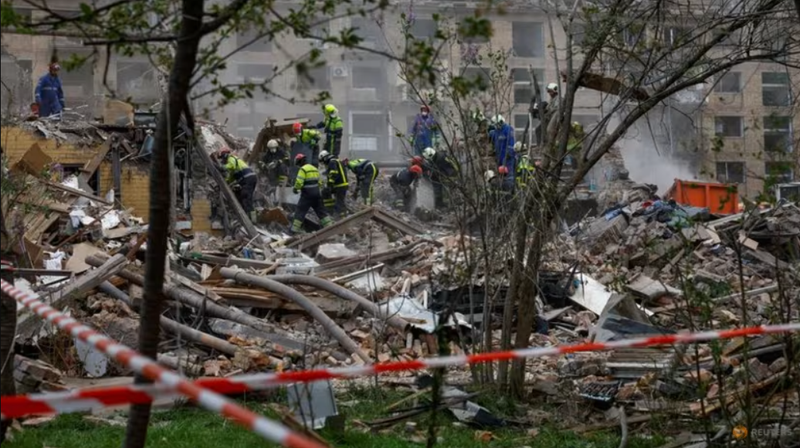 Lực lượng cứu hộ ở bên cạnh một tòa nhà chung cư bị trúng tên lửa ở Kiev, Ukraine vào ngày 24/4. Ảnh: Reuters.