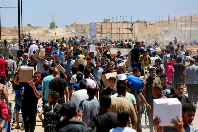 Người dân Palestine mang theo hàng viện trợ mà họ nhận được từ Quỹ Nhân đạo Gaza do Mỹ hậu thuẫn, tại trung tâm Dải Gaza, ngày 29/5. Ảnh: Reuters.