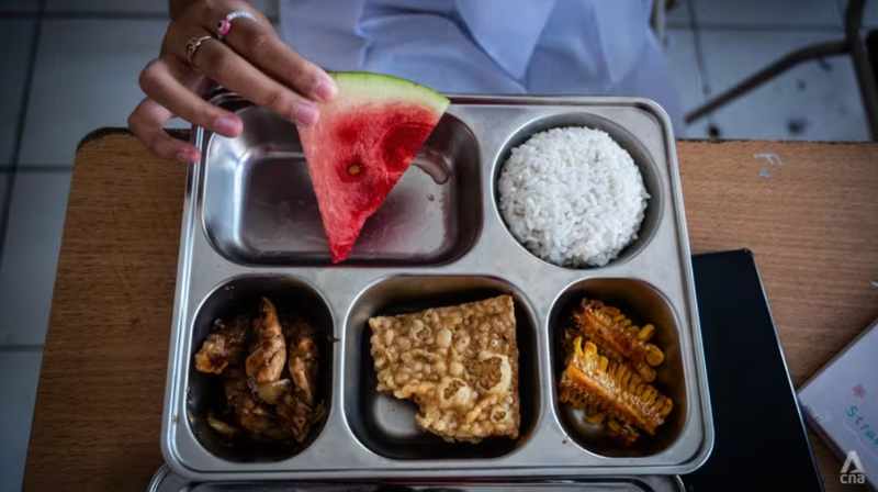 Một học sinh trung học cơ sở ở Bandung, Indonesia cùng khay thức ăn được cung cấp như một phần trong chương trình bữa ăn miễn phí của nước này. Ảnh: CNA.