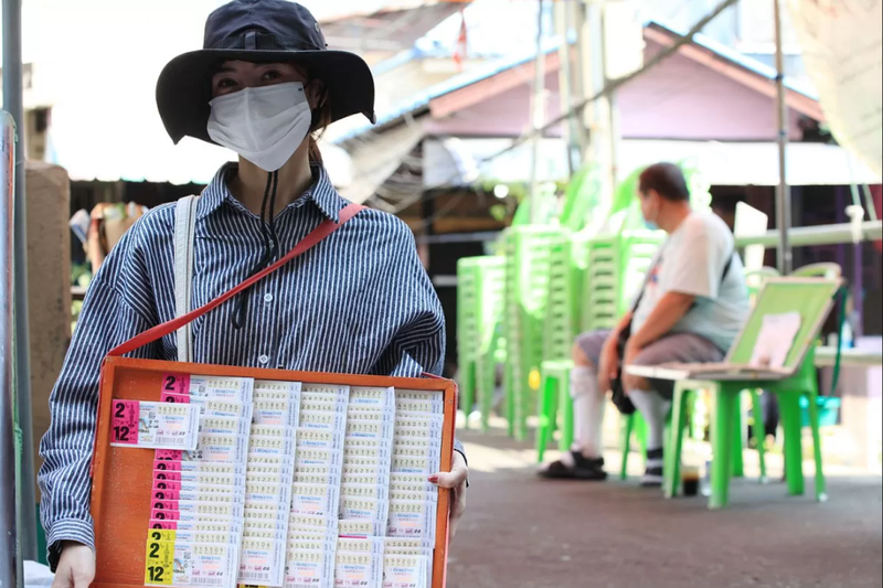 Một người bán vé số tại đường Ti Thong ở Bangkok, Thái Lan. Ảnh: Bangkok Post.