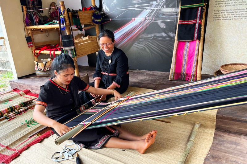 Bà H'Yam BKrông vui vẻ hướng dẫn thiếu nữ dệt thổ cẩm Bà H'Yam BKrông vui vẻ hướng dẫn thiếu nữ dệt thổ cẩm