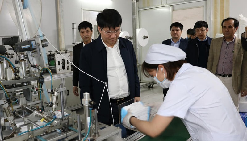Thứ trưởng Bộ Y tế Trương Quốc Cường quan sát hoạt động sản xuất khẩu trang. Ảnh: Khánh Phương