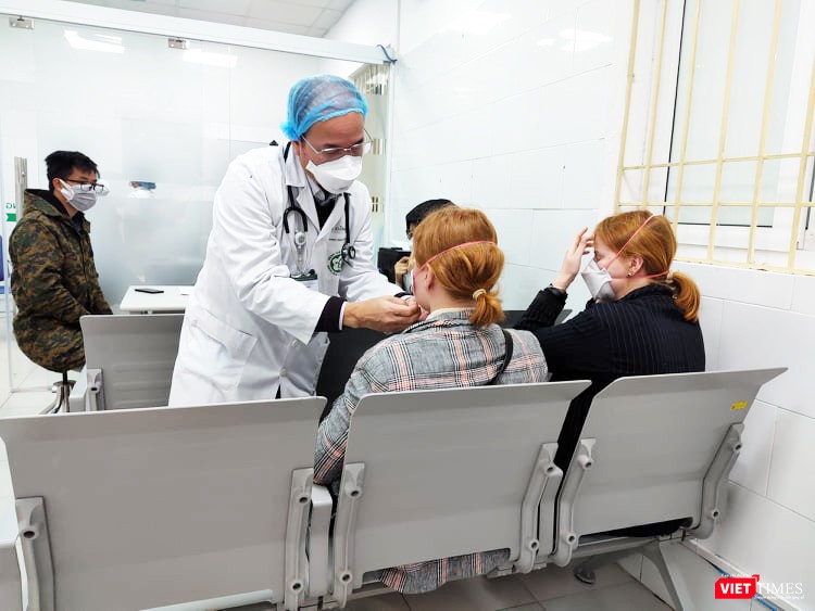 Bác sĩ hướng dẫn người đến khám đeo khẩu trang. Ảnh: Minh Thúy