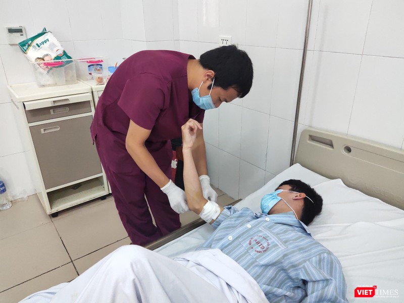 BS. Trần Duy Hiến thăm khám vết thương ở tay cho bệnh nhân. Ảnh: Minh Thúy