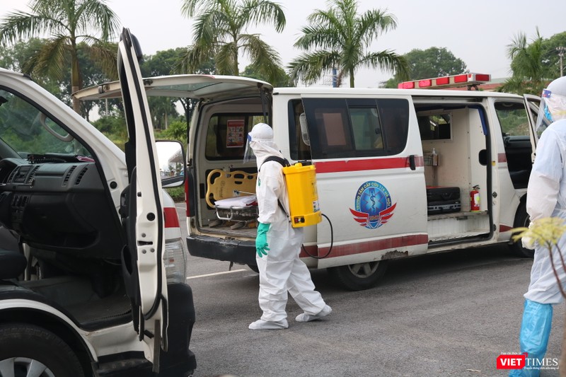 Nhân viên y tế khử khuẩn xe chở bệnh nhân (Ảnh: Minh Thúy) 