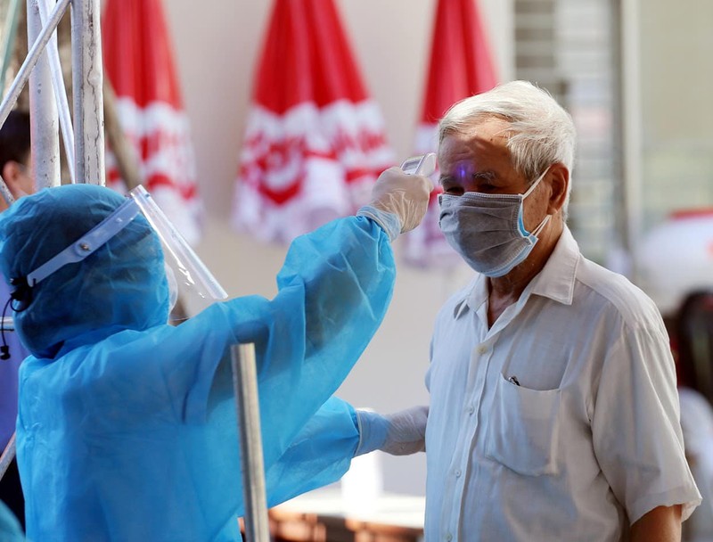 Cán bộ y tế đo nhiệt độ cho người dân (Ảnh: Lê Bảo - Minh Thùy) Cán bộ y tế đo nhiệt độ cho người dân (Ảnh: Lê Bảo - Minh Thùy)