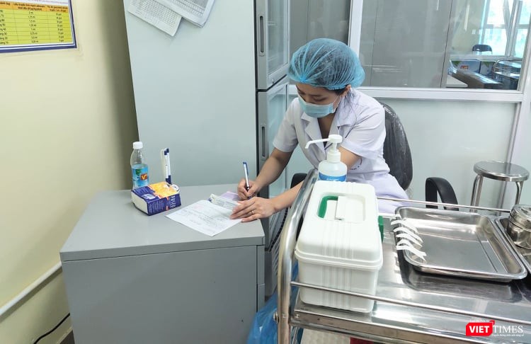 Nhân viên y tế ghi chú sau khi tiêm phòng cho trẻ (Ảnh: Minh Thuý)