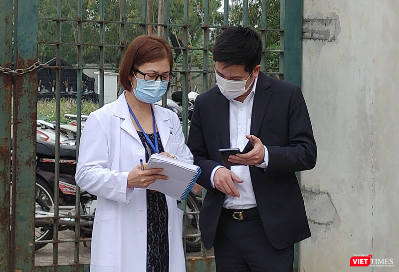 Nhân viên y tế làm việc bên ngoài cổng Trường Tiểu học Xuân Phương vào chiều qua (1/2) (Ảnh - Khánh Linh) 