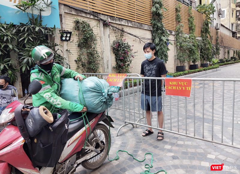 Người dân đứng sau rào chắn chờ nhận đồ (Ảnh - Minh Thuý)