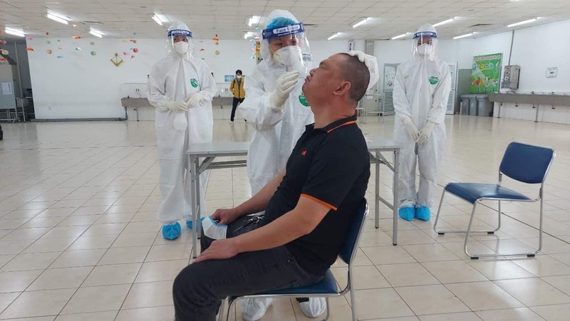 Nhân viên y tế lấy mẫu xét nghiệm COVID-19 cho công nhân (Ảnh - BYT)