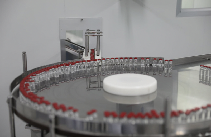 Sau khi được soi kĩ lưỡng, các lọ vaccine được chuyển sang bàn xoay dán nhãn