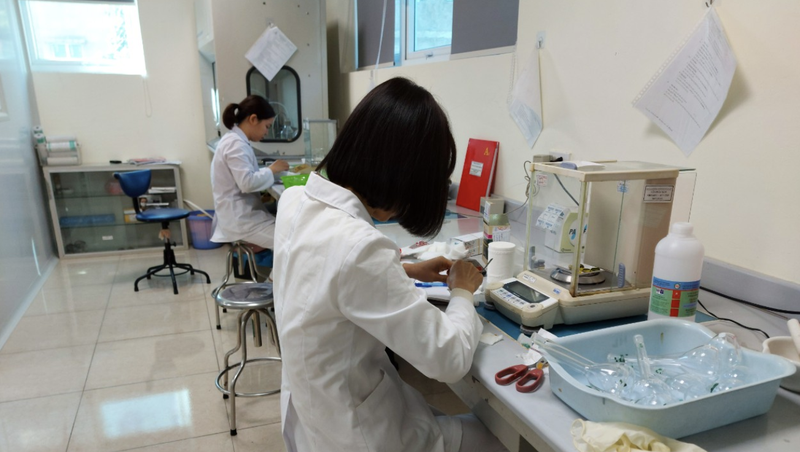 Cán bộ Trung tâm Kiểm nghiệm thuốc, mỹ phẩm, thực phẩm Hà Nội cân phân tích mẫu thuốc (Ảnh - SYTHN)
