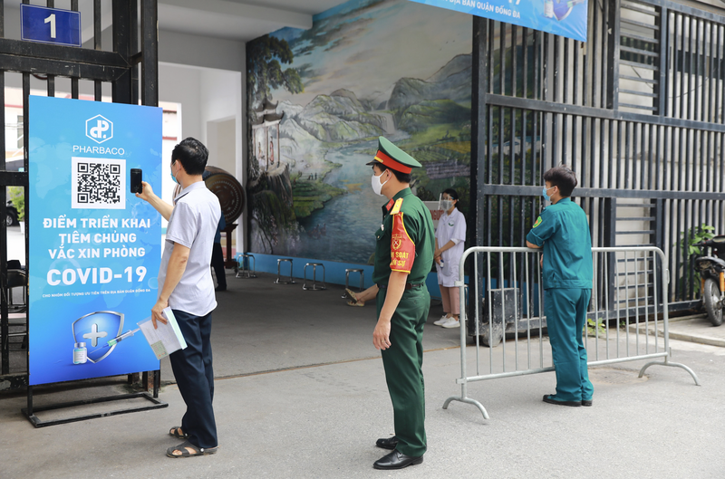 Người dân đến tiêm được hướng dẫn khai báo y tế qua hệ thống quét mã QR, tránh tiếp xúc không cần thiết (Ảnh - Pharbaco)