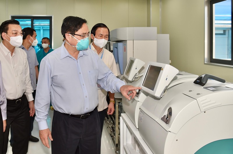 Thủ tướng Phạm Minh Chính kiểm tra hệ thống máy xét nghiệm COVID-19 tại phòng Lab của bệnh viện.