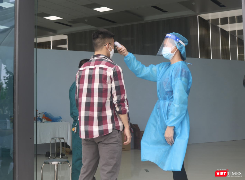 Kiểm tra nhiệt độ trước khi tiêm vaccine (Ảnh - Minh Thuý)