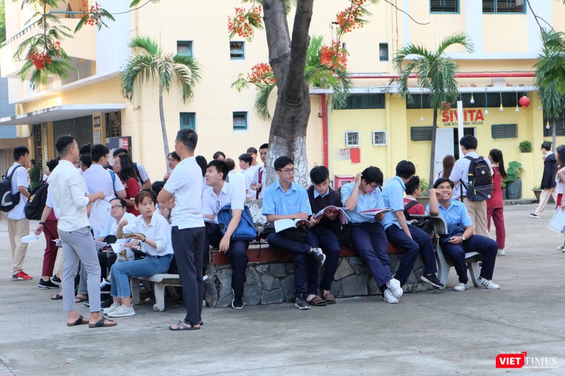 Thí sinh đến sớm, tranh thủ ôn bài với bạn trong khuôn viên trường thi