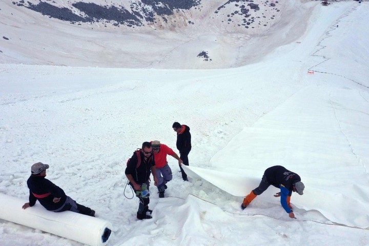 Các công nhân đang phủ bạt lên sông băng. Ảnh: Internet