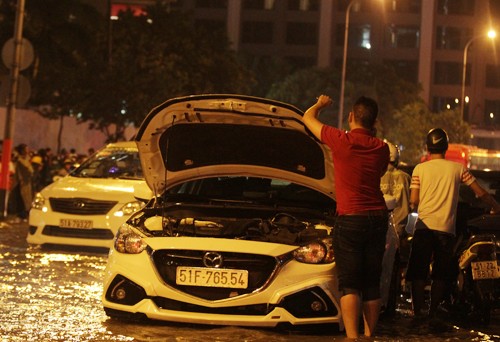 Hàng chục ôtô chết máy nằm giữa dòng nước ngập. Nhiều xe chết máy chắn ngang đường nên ùn ứ kéo dài cả km. Chủ xe phải gọi thợ, người nhà mang bình ắc quy đến thay. Hàng chục ôtô chết máy nằm giữa dòng nước ngập. Nhiều xe chết máy chắn ngang đường nên ùn ứ kéo dài cả km. Chủ xe phải gọi thợ, người nhà mang bình ắc quy đến thay.